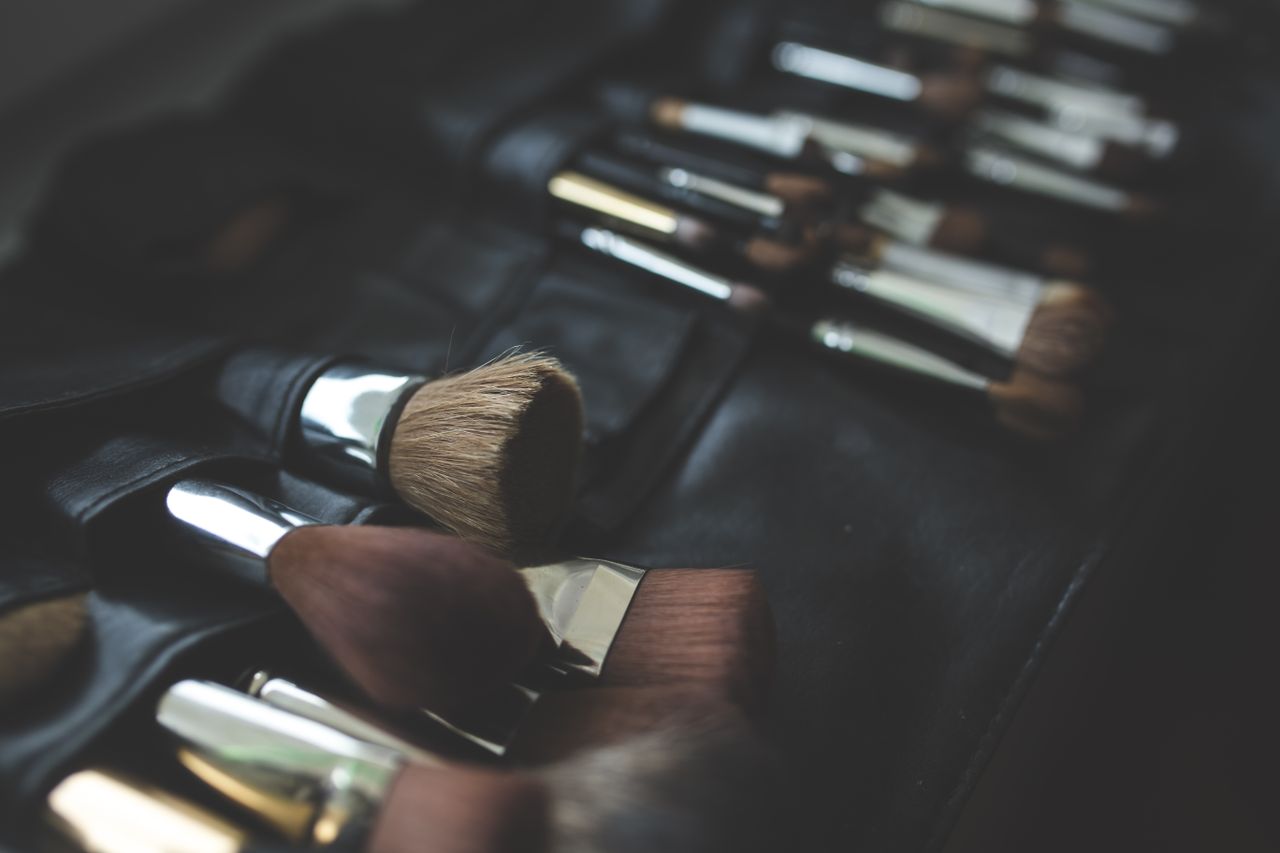 A stylish arrangement of makeup brushes set against a dark, elegant background.